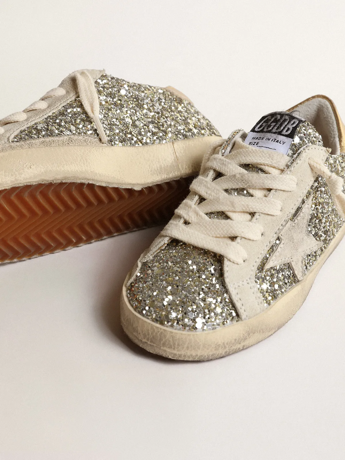 Super-Star Junior in glitter with a suede star and gold heel tab